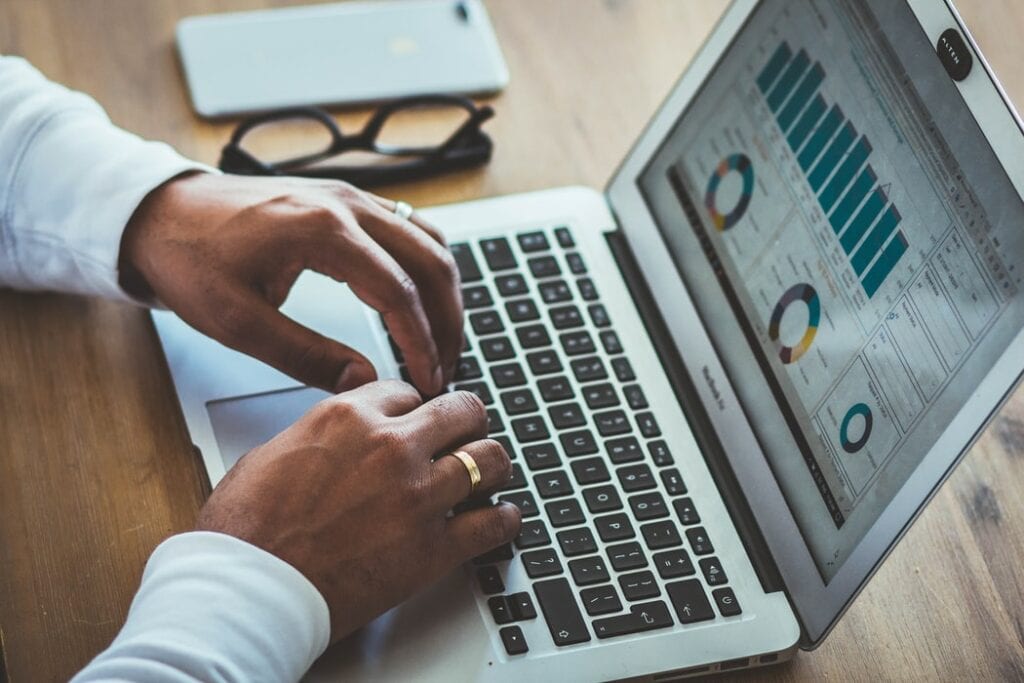 Person looking at bar graphs and pie charts on MacBook Pro laptop