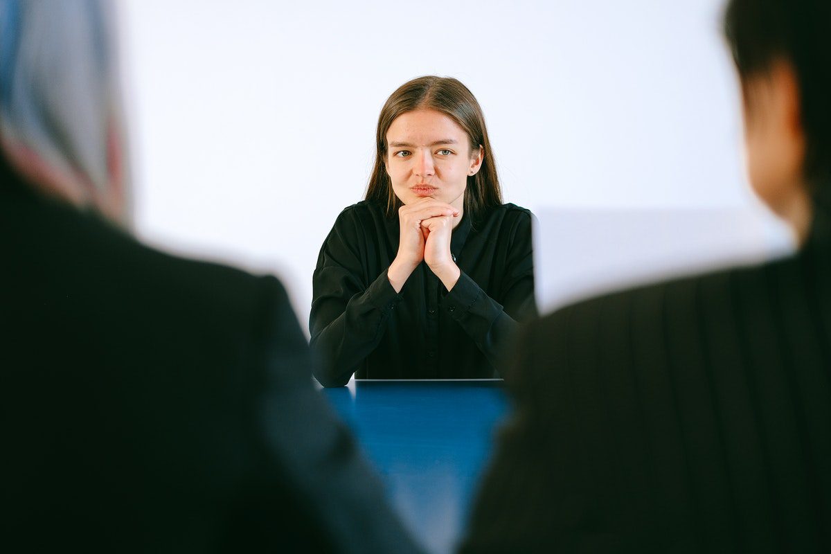 a woman in an interview pondering her answer to a follow-up question Chemical Engineer Interview Questions and Answers