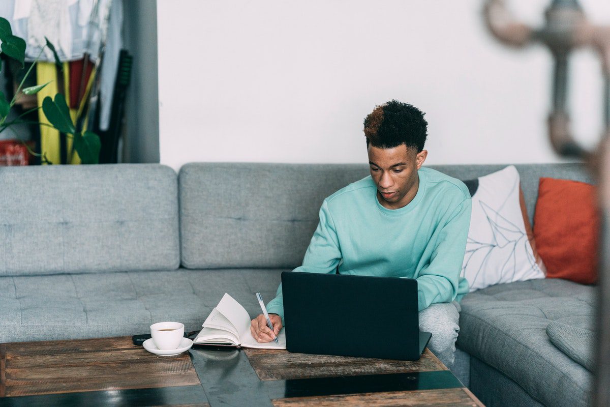 Person studying using a computer and a notebook. Programmer Interview Questions and Answers