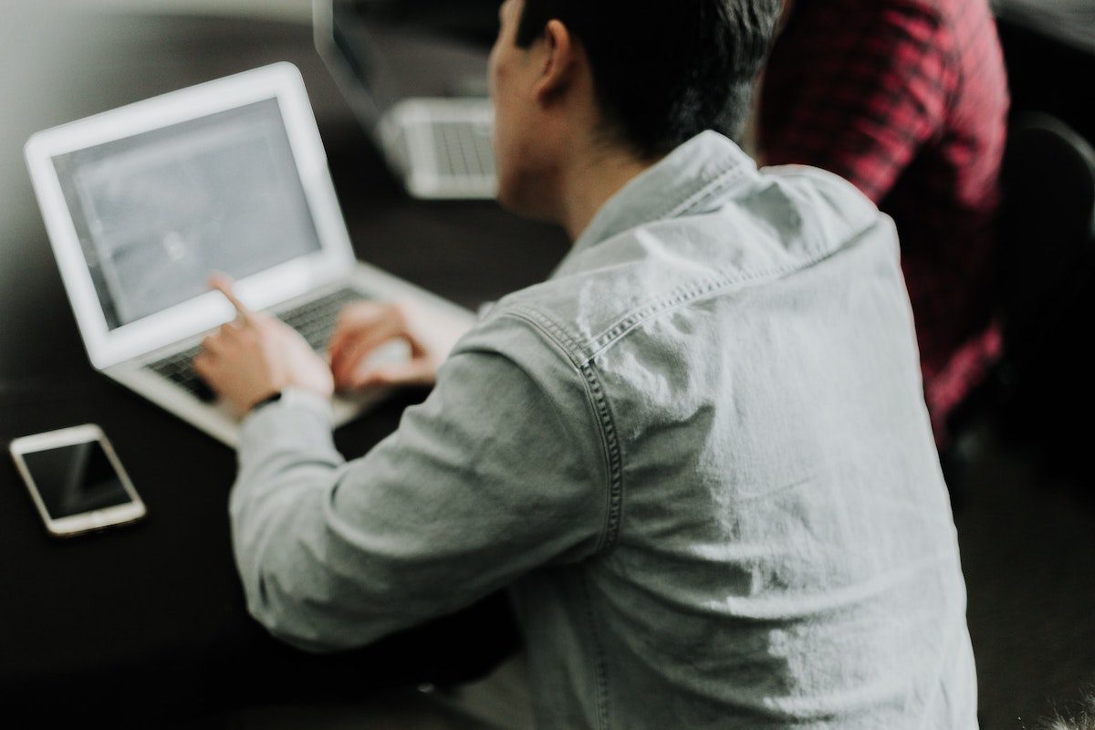 person looking at his laptop how to become a research analyst