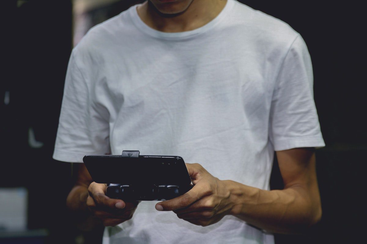 A young professional testing a video game on a smartphone. Game Development Associate Degrees