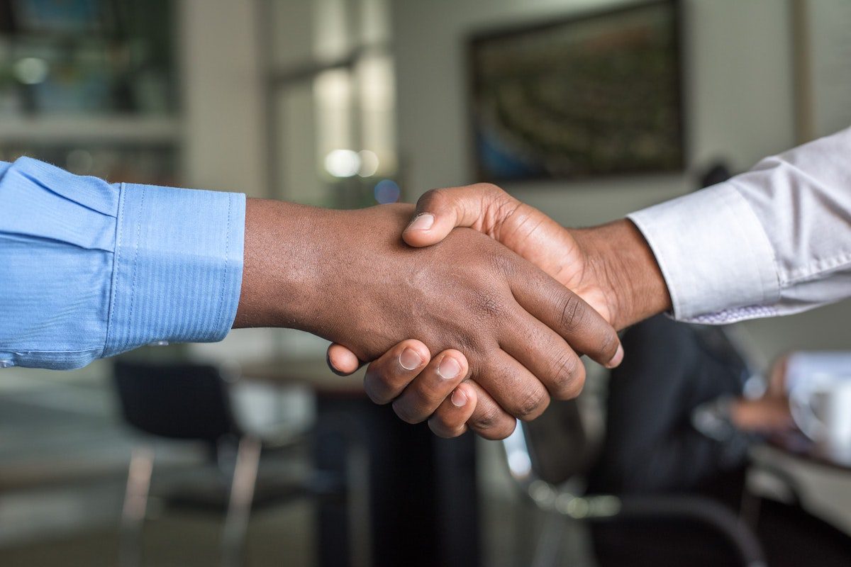 Two people shaking hands. IT Manager Interview Questions and Answers