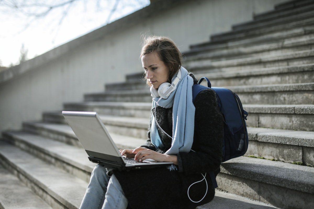  Student studying on a staircase with a laptop. Jobs for Environmental Engineering Majors