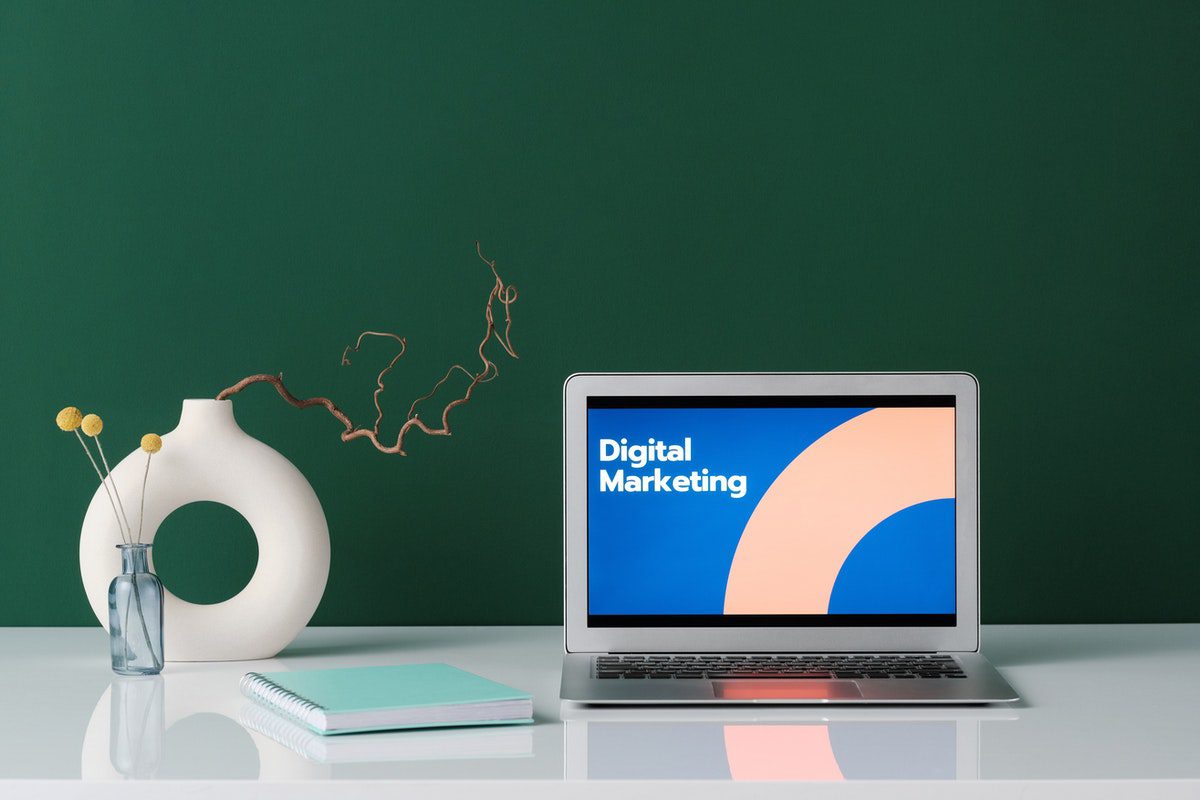 A laptop on a white desk displaying the words “digital marketing”. Digital Marketing Apprenticeships