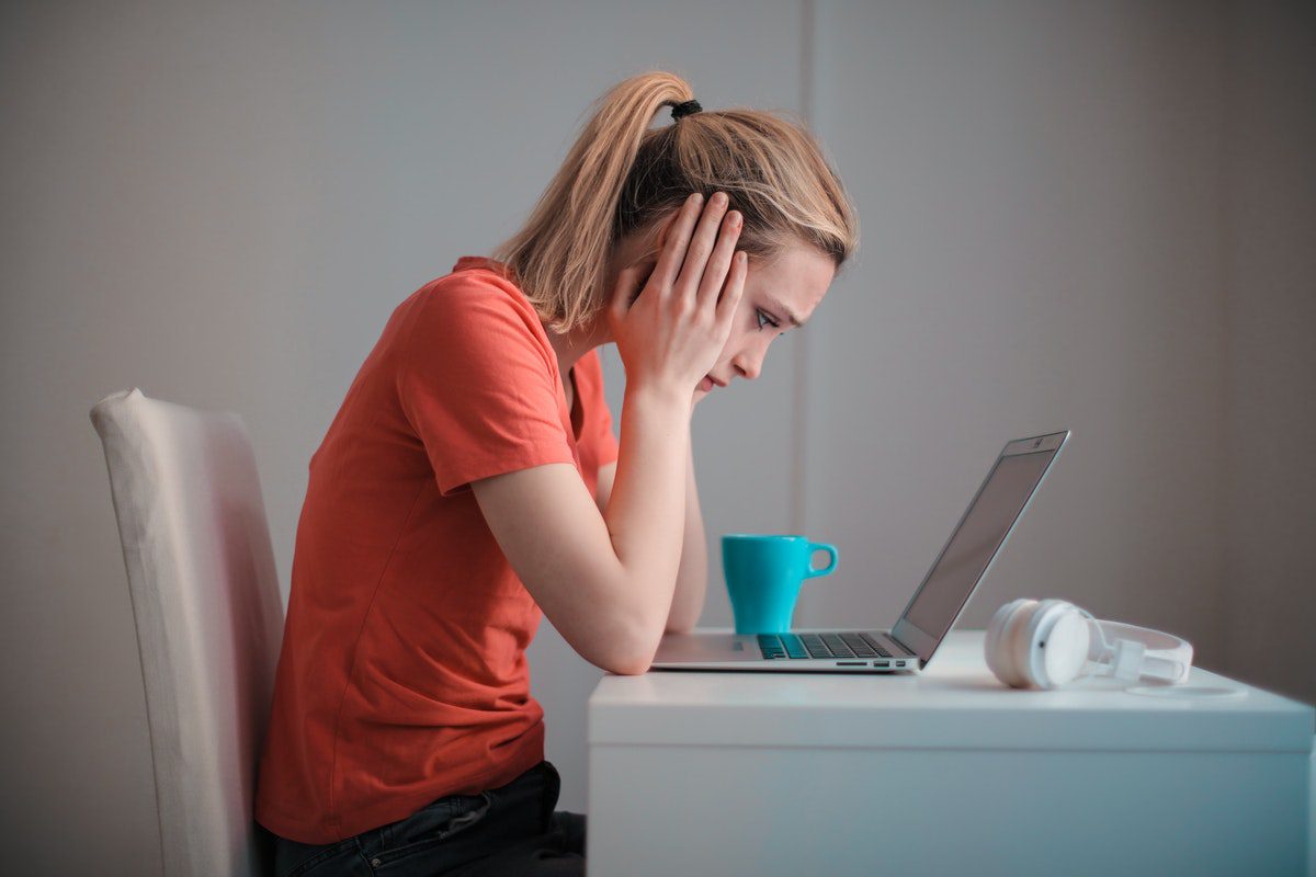 a woman staring at her laptop while drinking a cup of tea. Java Apprenticeships