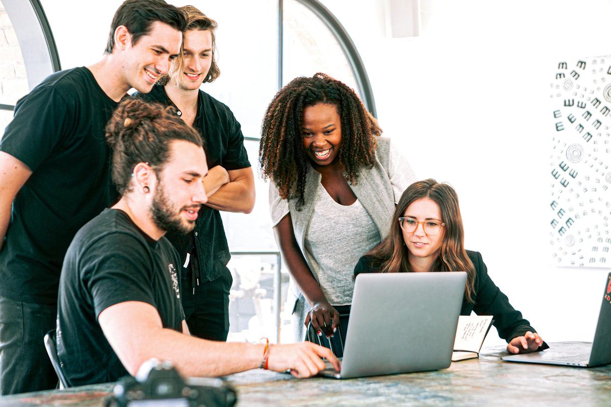 A group of people looking at a laptop. Machine Learning Apprenticeships