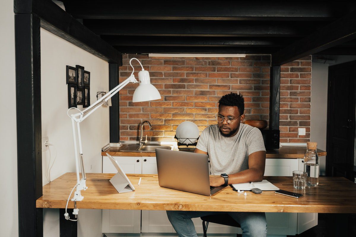 Person at home working at a computer desk on a laptop. Online Cryptography Courses