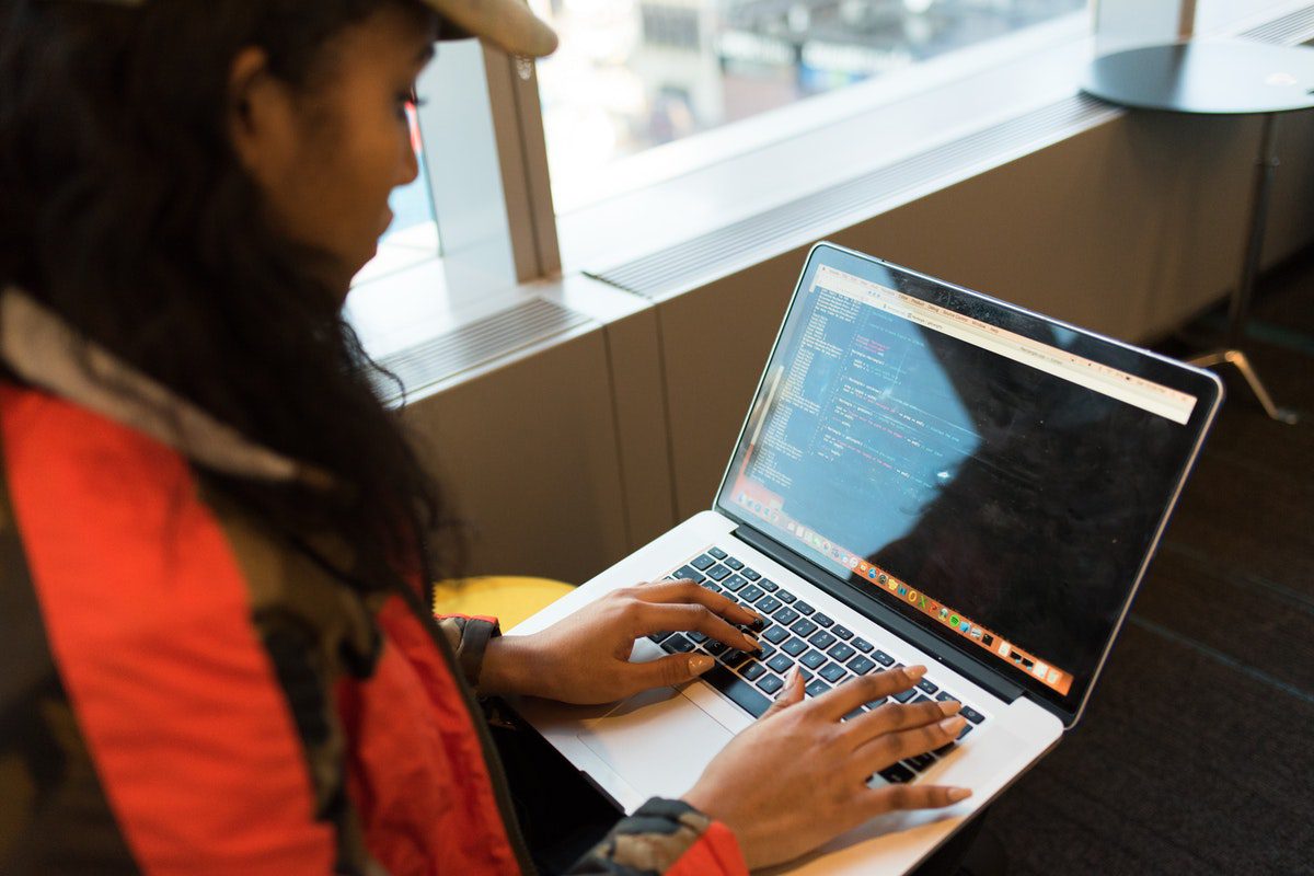 A professional partaking in Python courses online to learn code on her laptop.