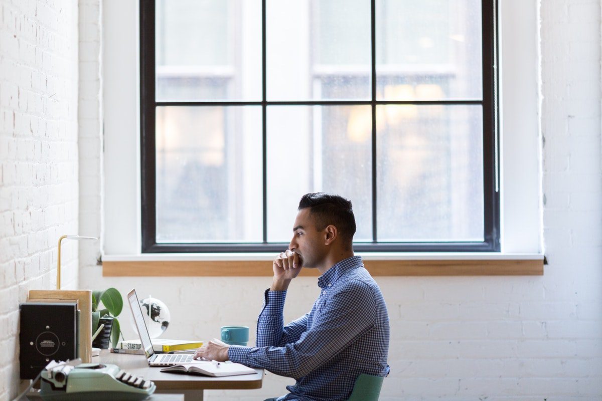 Man sitting in front of a laptop taking online SQL courses.