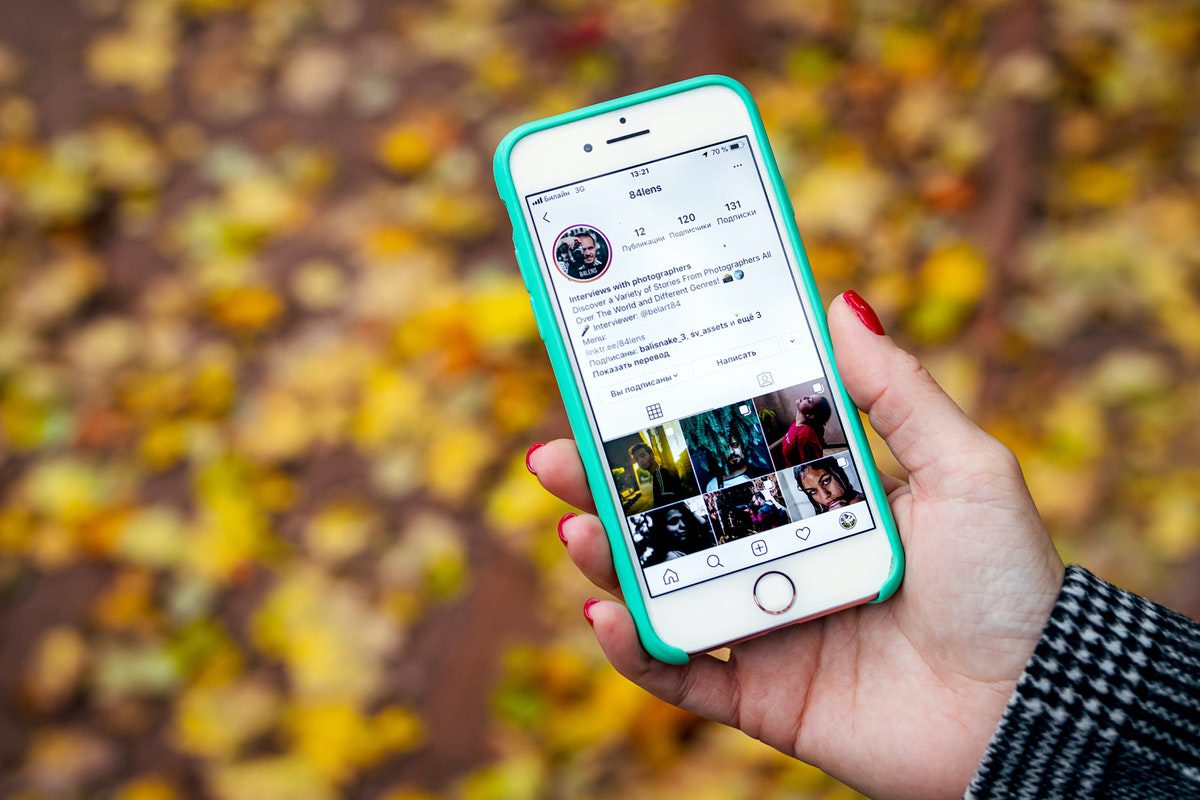 A person holding a phone up which shows their Instagram feed. Social Media Marketing Apprenticeships