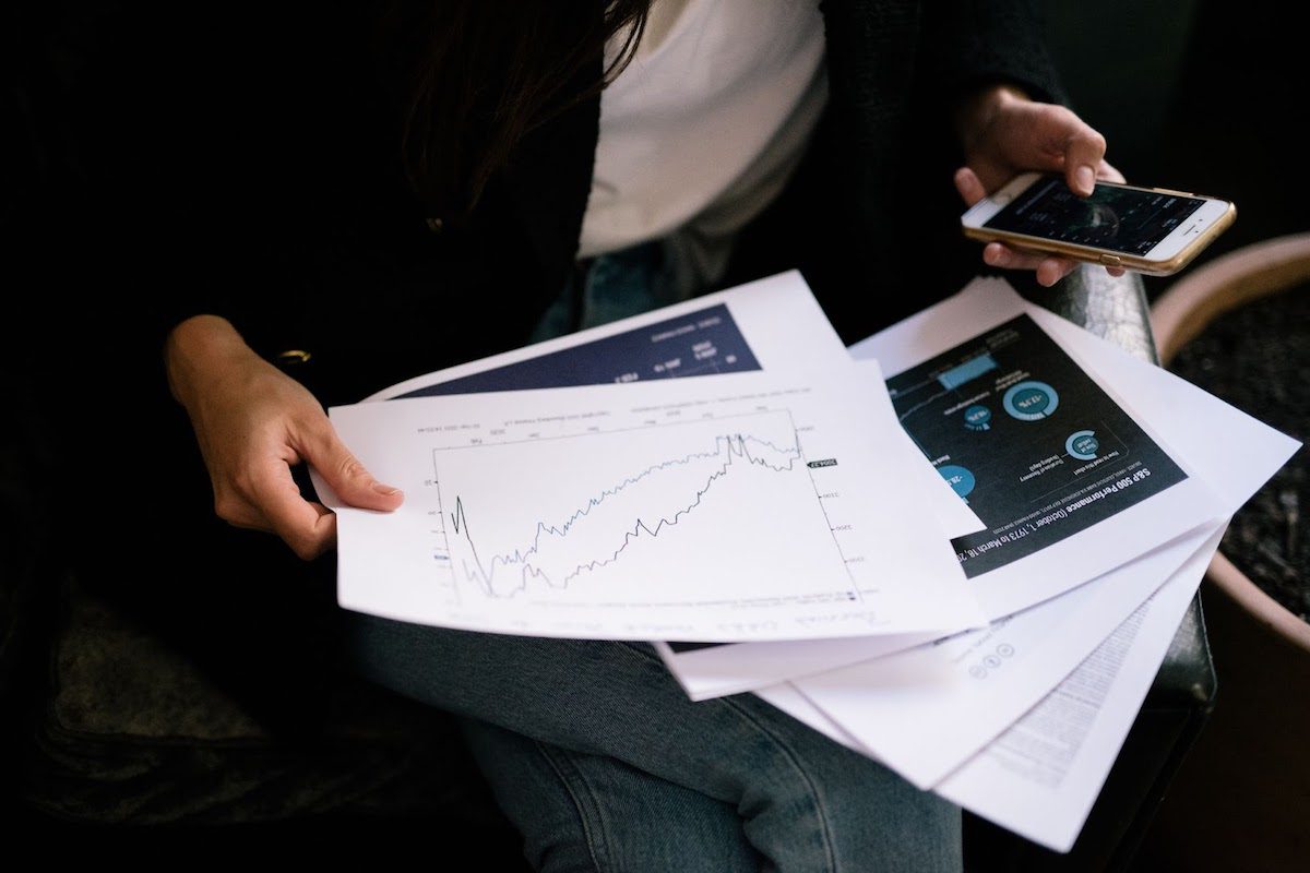 A lady holding papers with graph drawings. To succeed in business, you cannot underestimate the power of big data, business analytics, and business intelligence. 