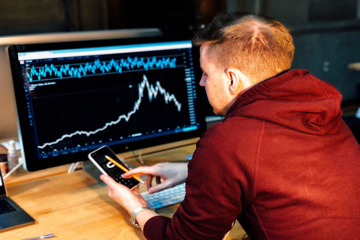 A man looking at a graph and using a calculator.