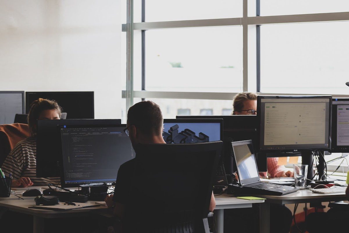 Computer programmers working on code at a desk.