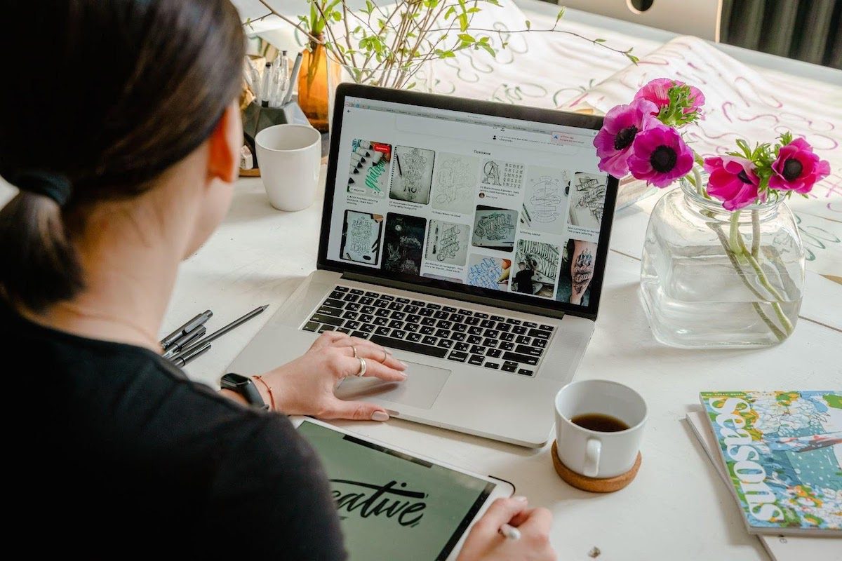 Woman looking at graphic designs on a laptop.