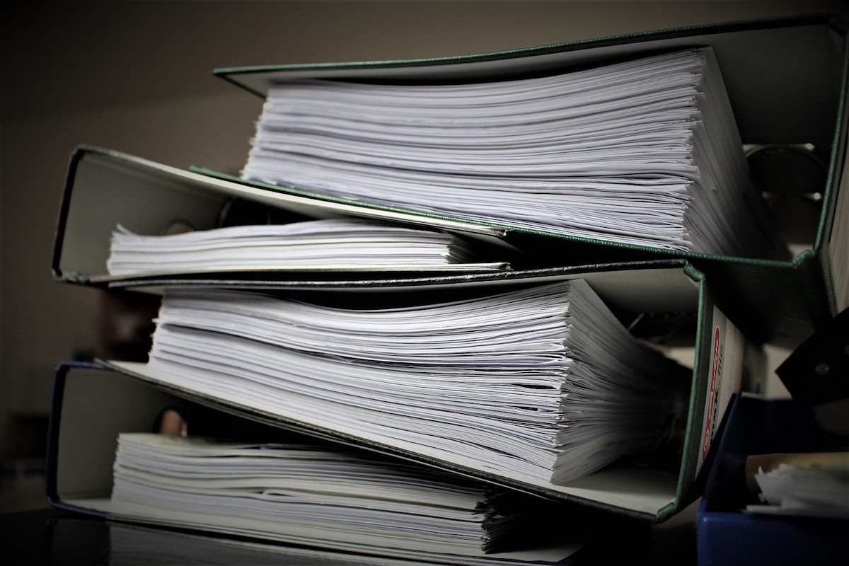 A stack of binders filled with paper.