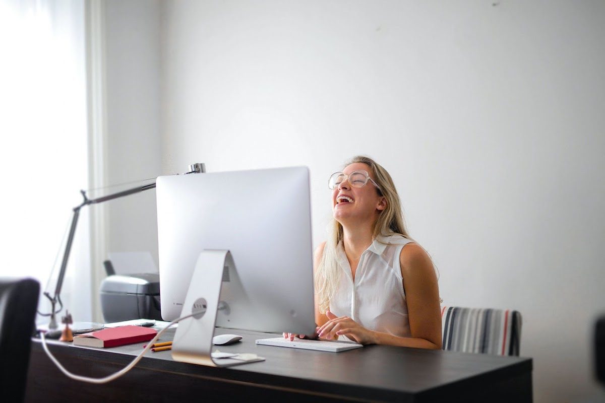 Women with glasses sitting in front of a desktop computer. Online AWS Courses