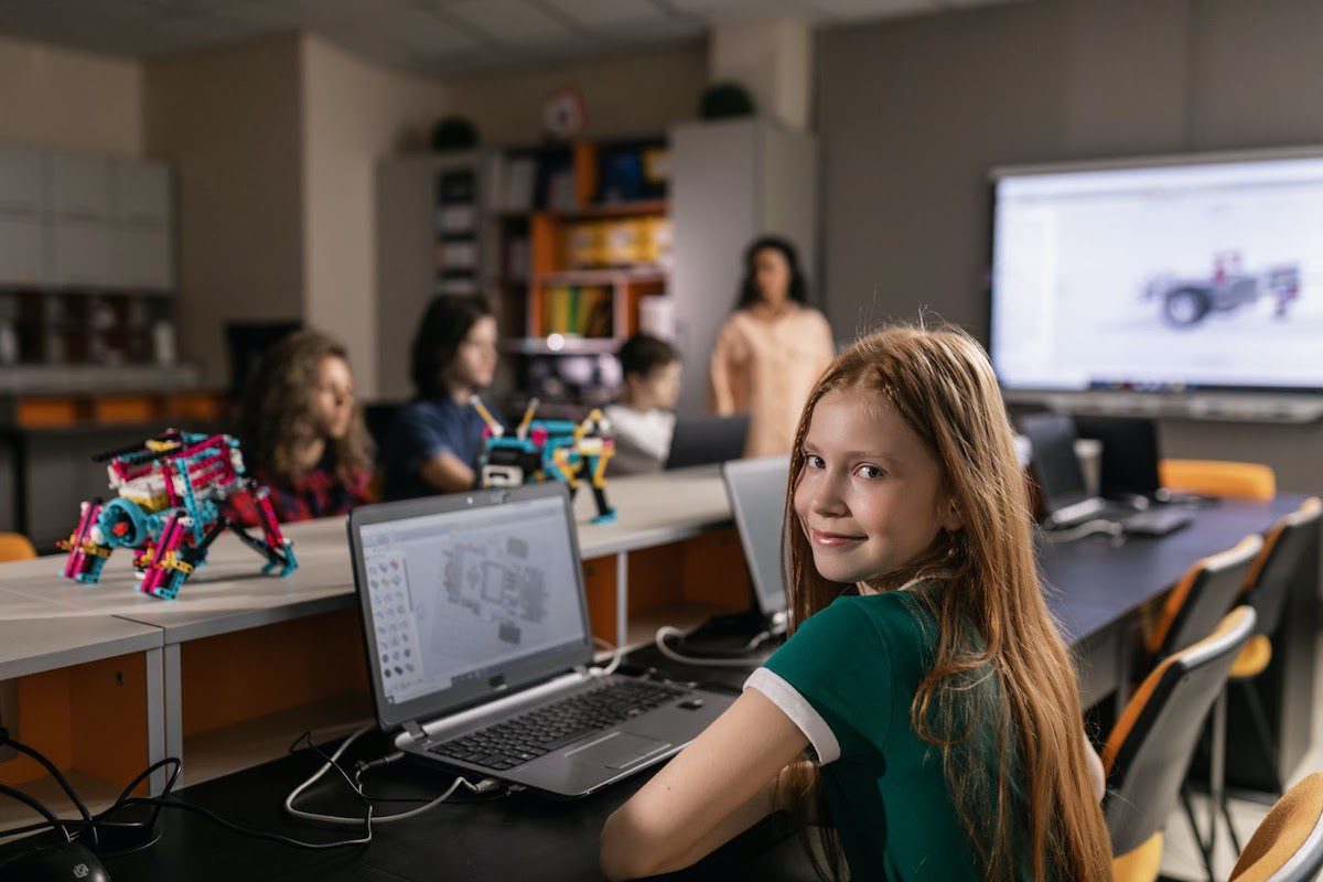 a girl using her laptop while in a robotics class