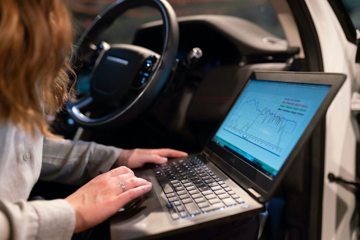 An engineer testing a vehicle’s sound system using an application on a laptop.