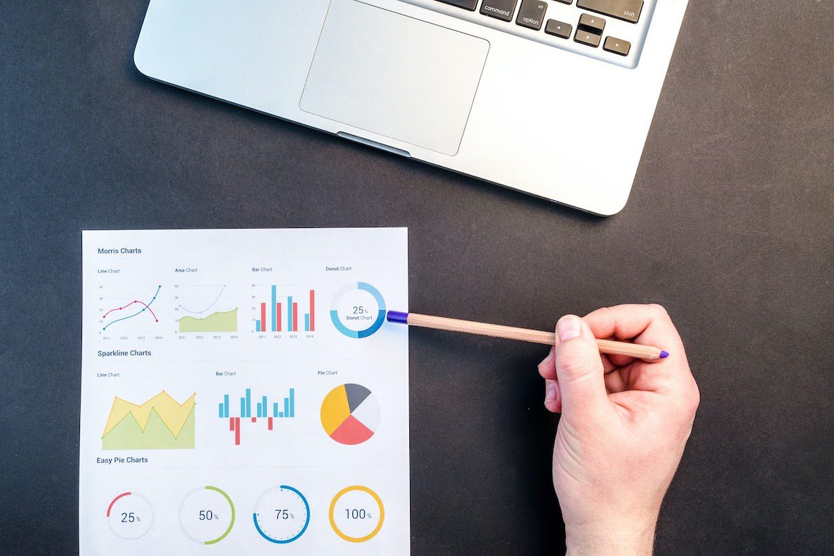 A woman holding a pen pointing to a pie chart. 