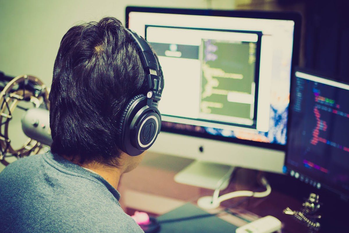 Man with headphones using Unity on computer