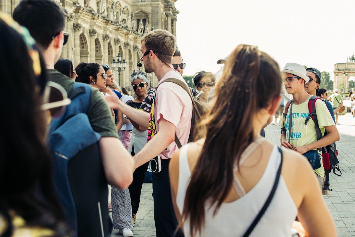 A group of tourists listening to a tour guide. Seasonal Careers