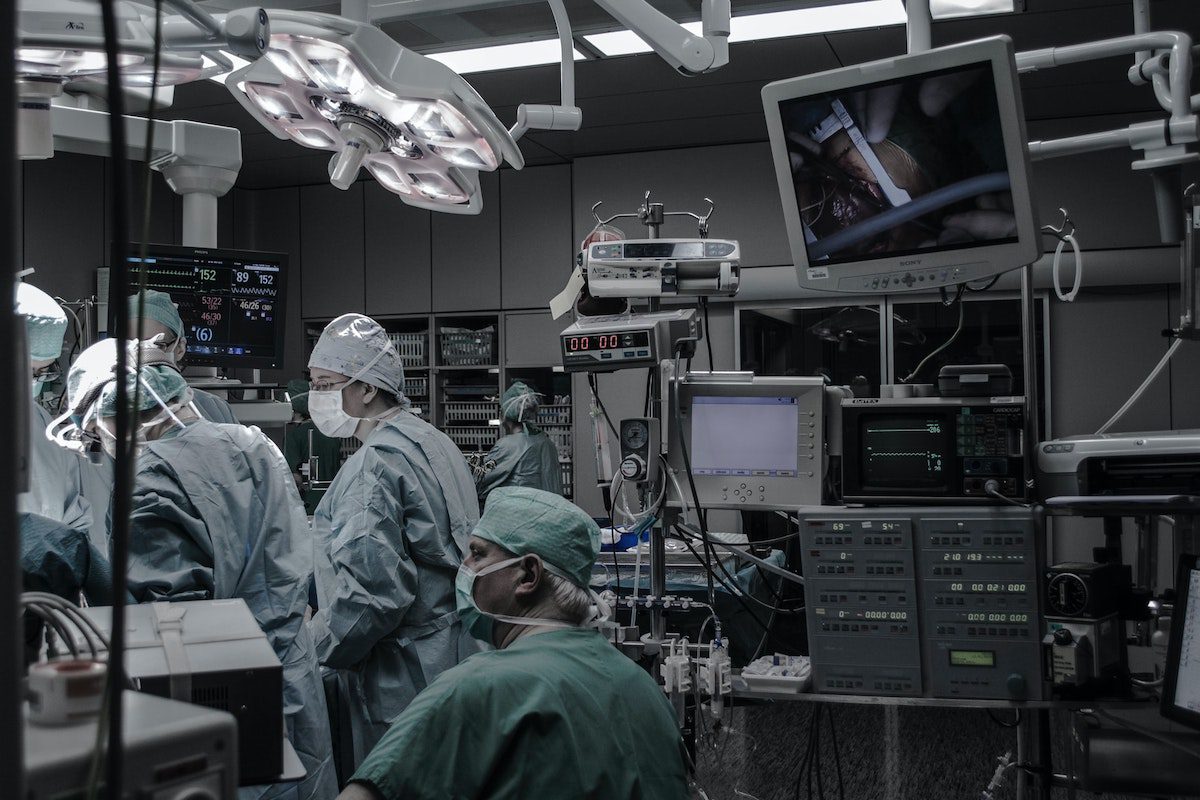 Surgeons inside an operating room with medical equipment. Healthcare Jobs Without a Degree