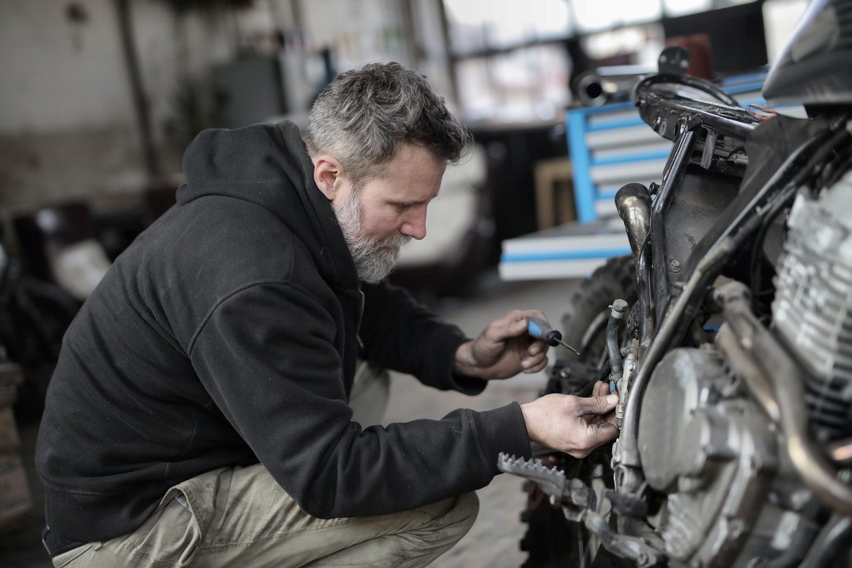 A man repairing his car. How Much Can You Make on Getaround?