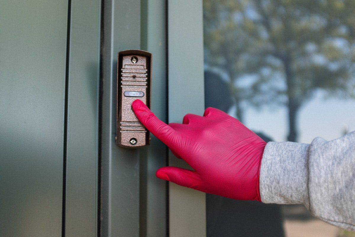 A hand in a red plastic glove ringing a doorbell. How Much Can You Make on Gopuff?