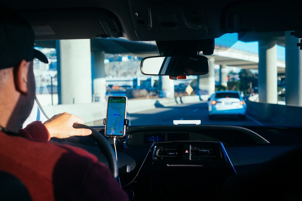 A Lyft driver using a phone to display a map. How Much Can You Make on Lyft?
