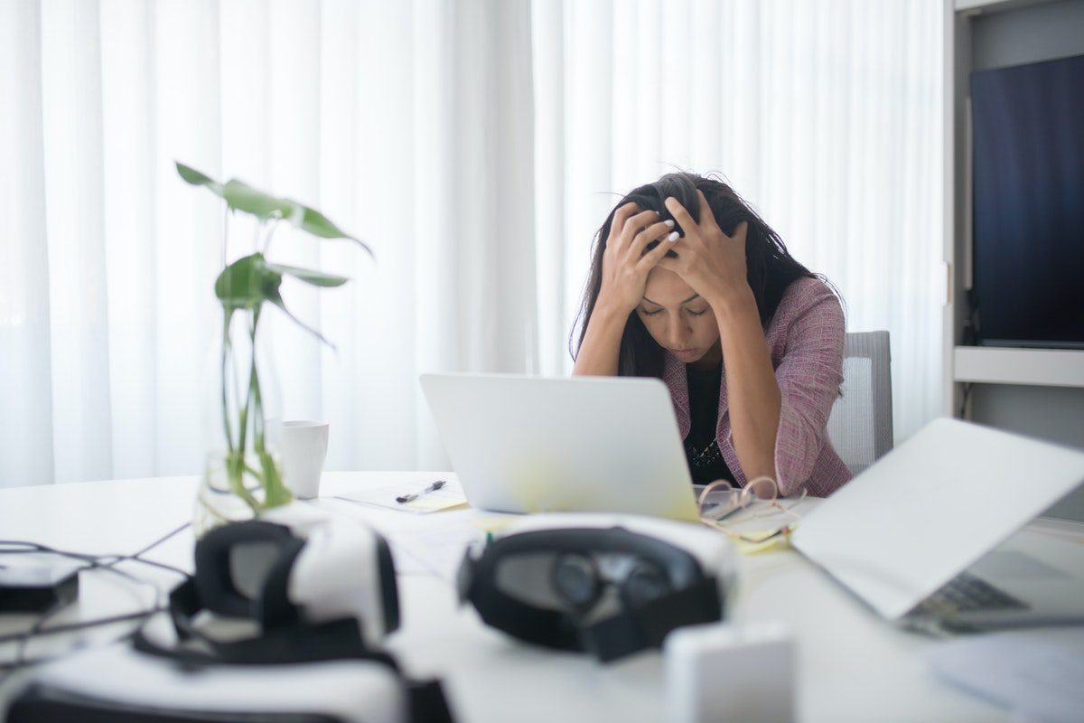 A frustrated woman seated at a table with her open laptop. Cover Letter for Internal Position