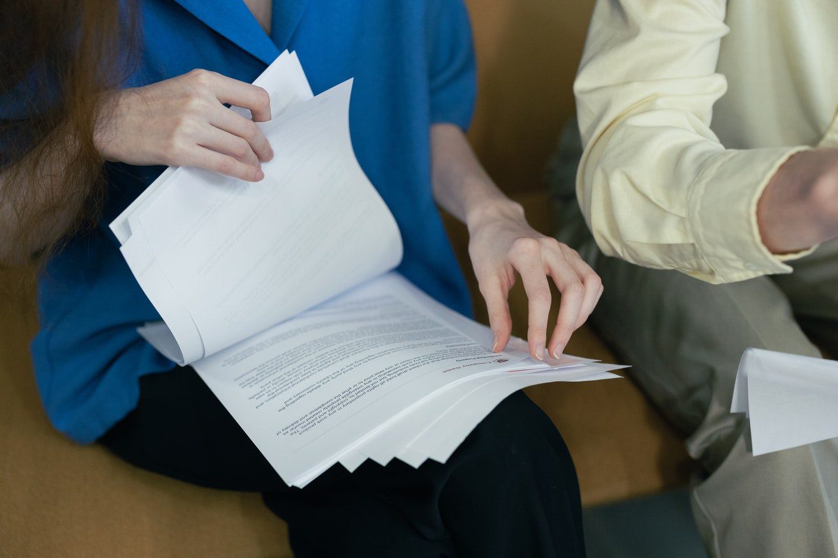 Two people rifling through stacks of paper on their laps. Internship Cover Letter