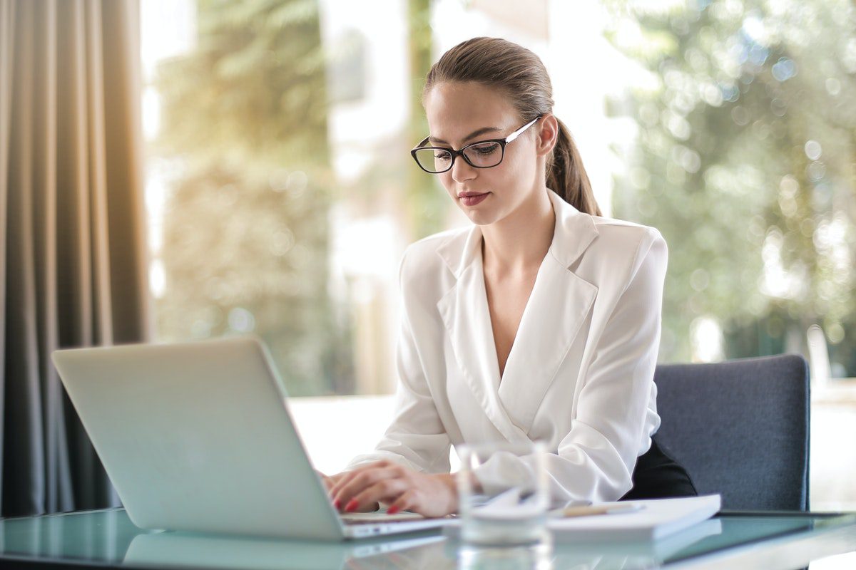 A woman working on her laptop while sitting in an office. Jobs That Pay 15 An Hour