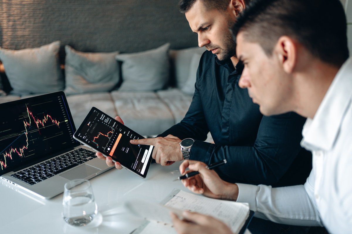 Two men working on a tablet screen that is displaying projections. SEO Manager Job Satisfaction