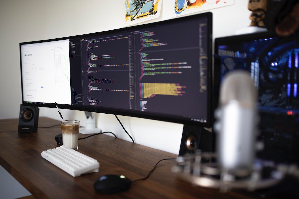 A widescreen computer showing Angular coding on a table with a glass of white and brown content in it. Angular Best Practices