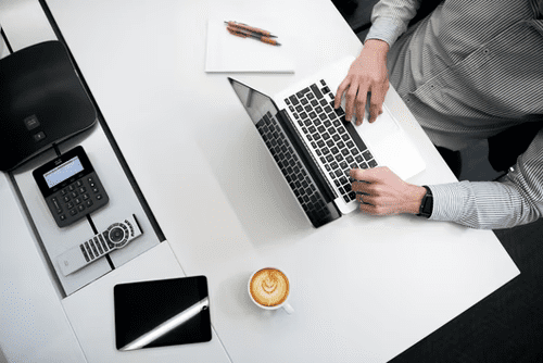 A person using a laptop on a white table