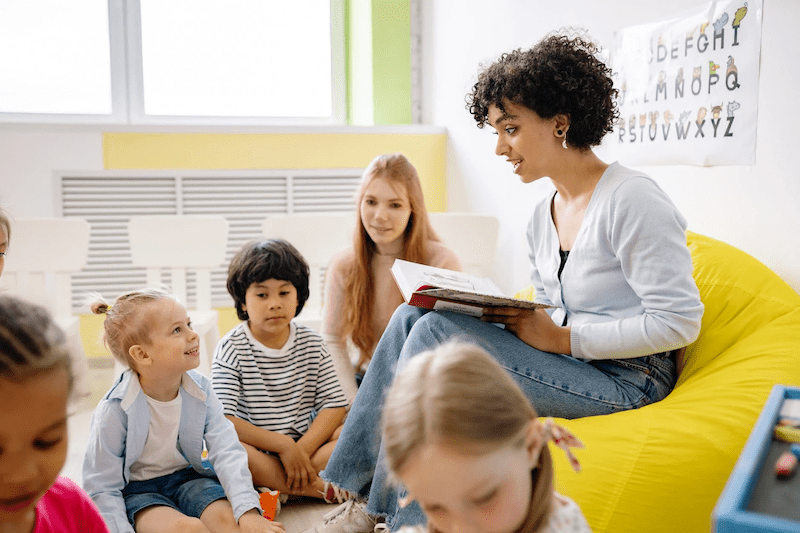 Woman reading a book to children