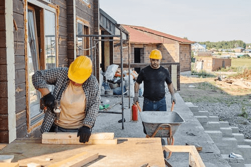 Man and woman wearing yellow hardhats working on construction site