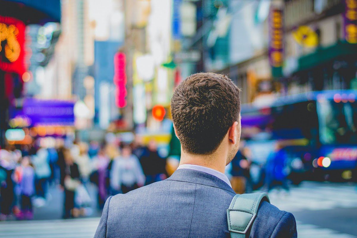 A man in a suit standing at Times Square.