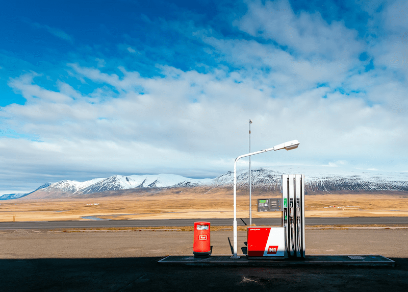 Pump at a retail gas station in a rural area with a snowy mountain in the background.