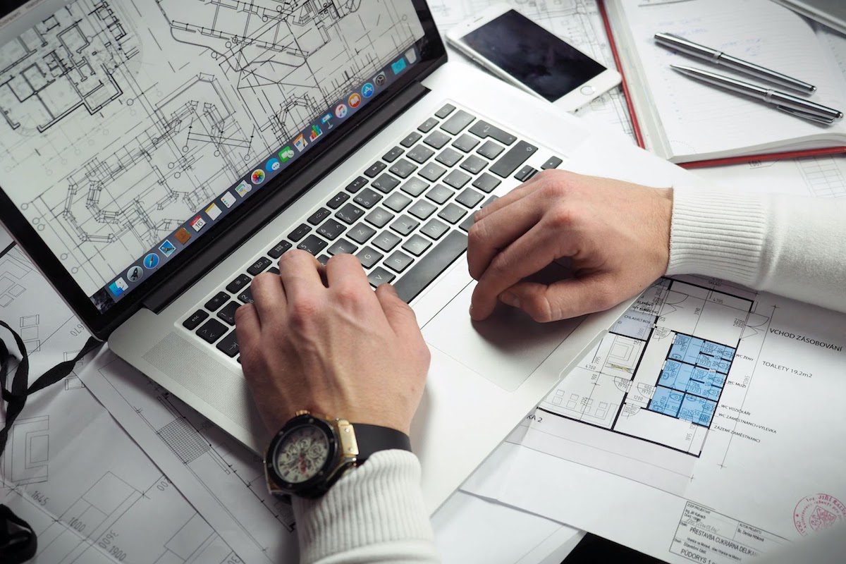 A man working on a project plan on a laptop.