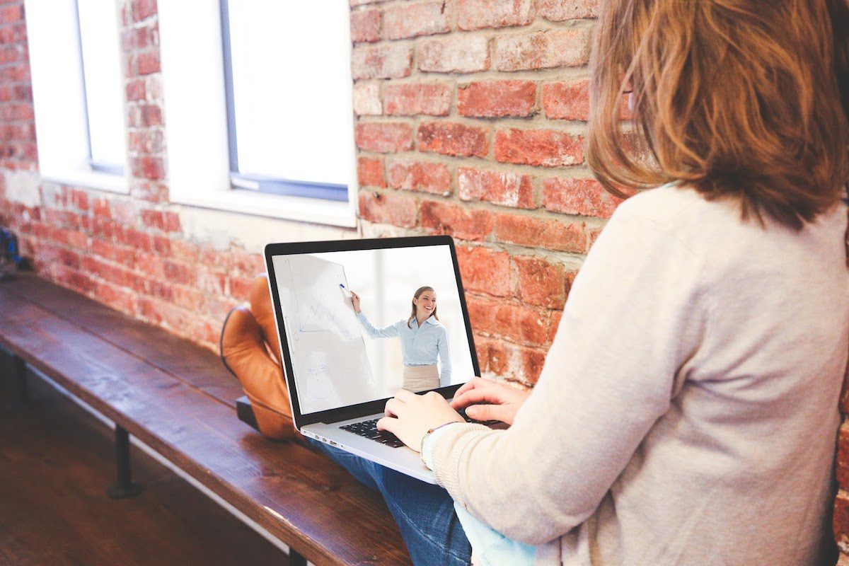 A woman attending a virtual classroom on her laptop