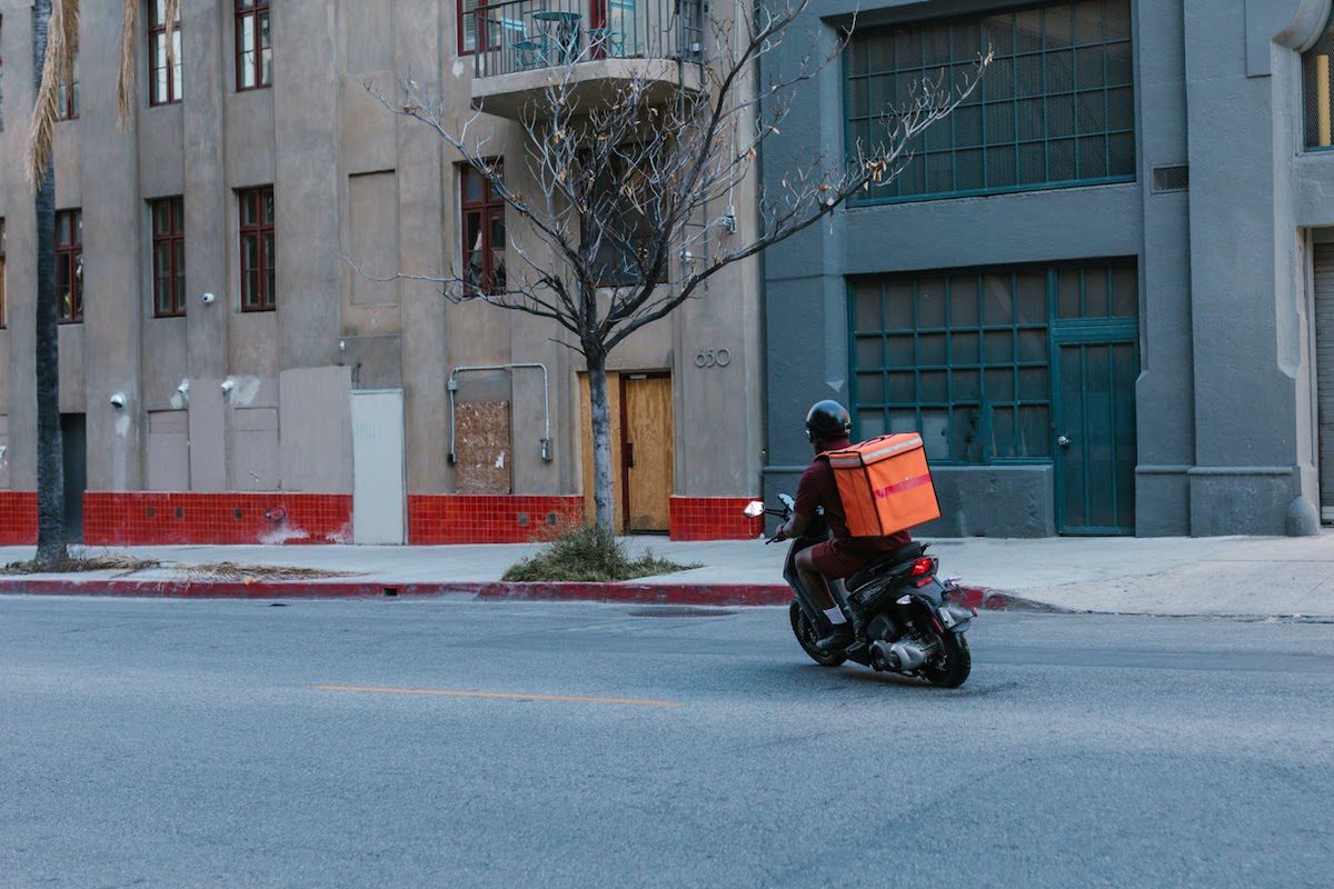 a man on his motorbike making a delivery