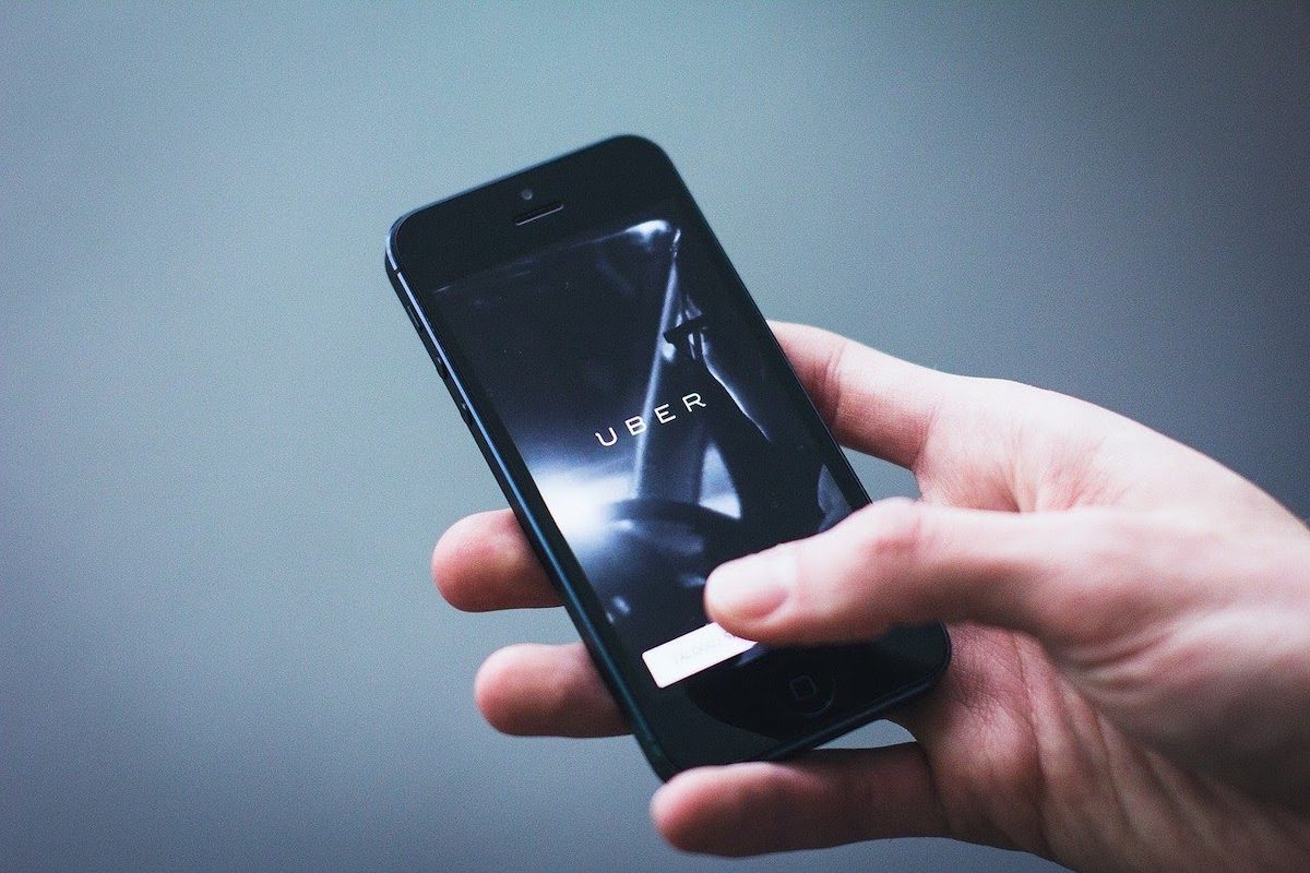 The Uber app is displayed on a mobile device held in a hand.  How Much Can You Make on Uber?