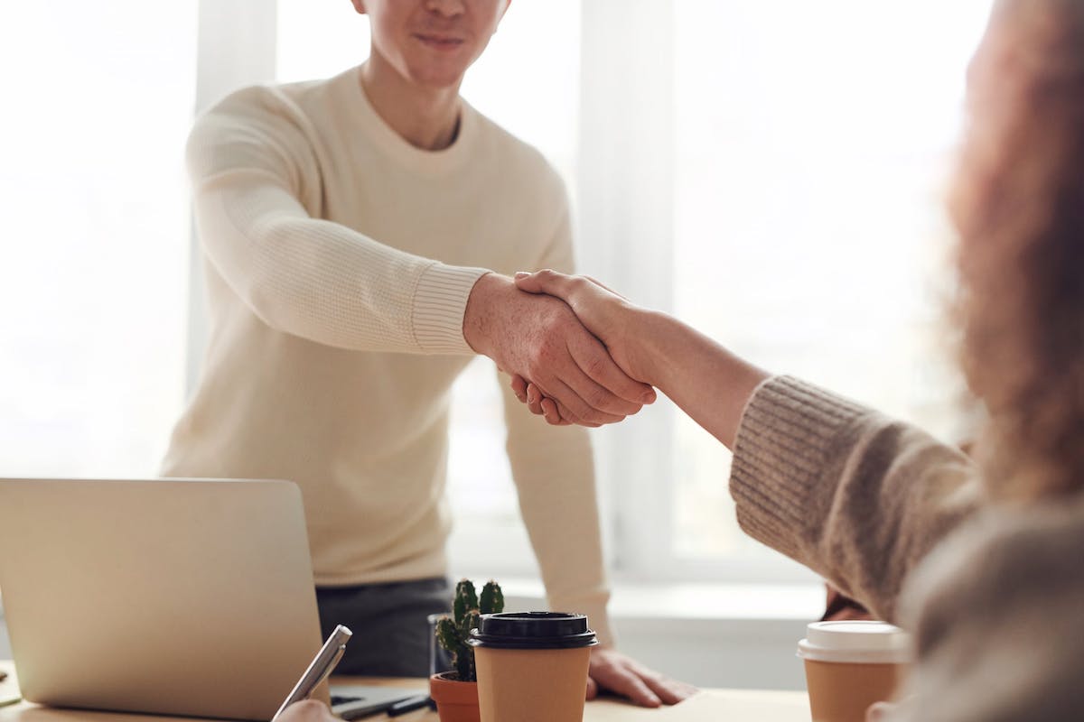  Two people shaking hands indicating a successful negotiation. Jobs That Pay Well