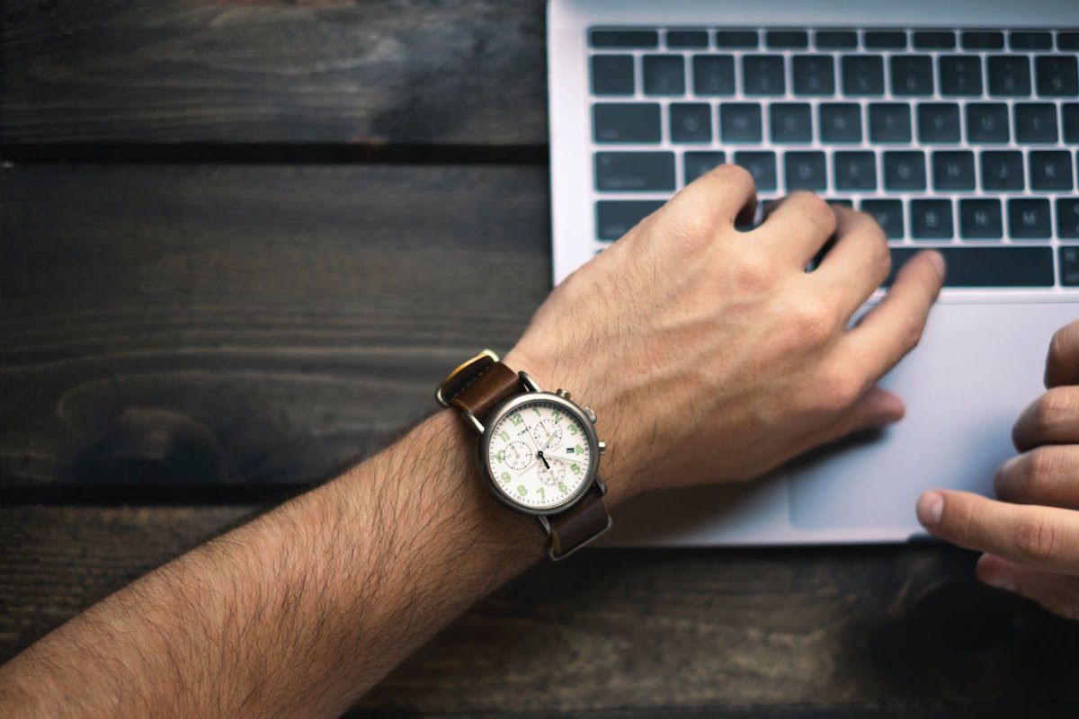 A man working on his laptop wearing a watch