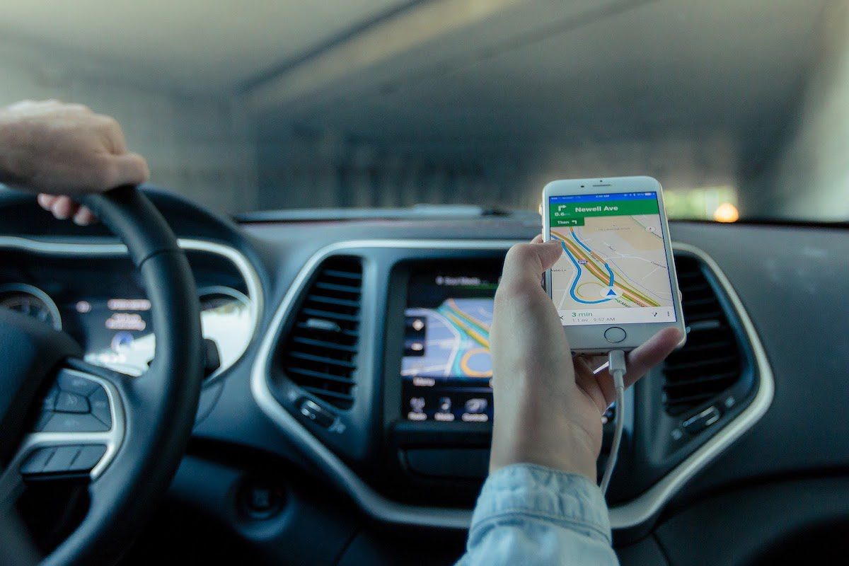 The dashboard of a car with a phone showing a navigation app.