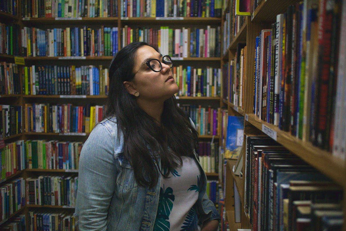 a woman looking at books in the library