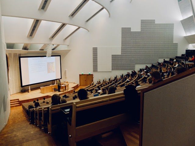 A university classroom with students and a professor