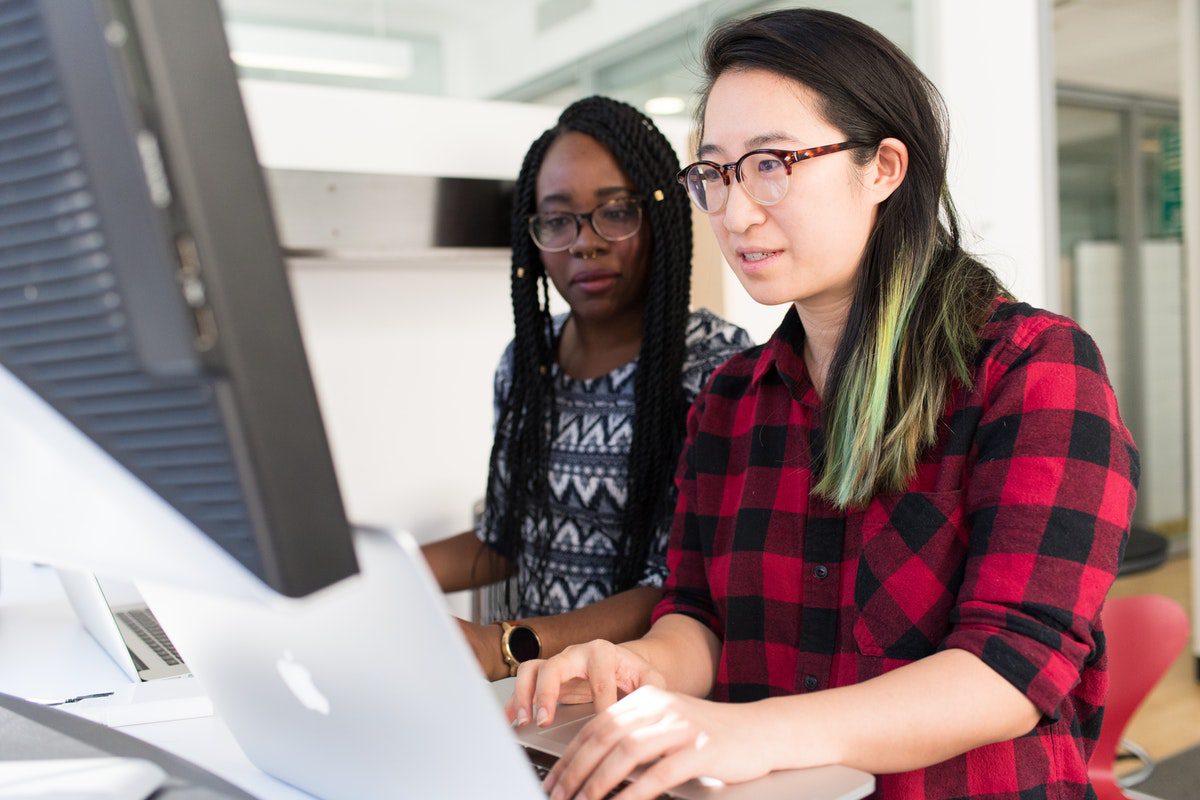 Women learning to code using their laptops. Best Coding Blogs