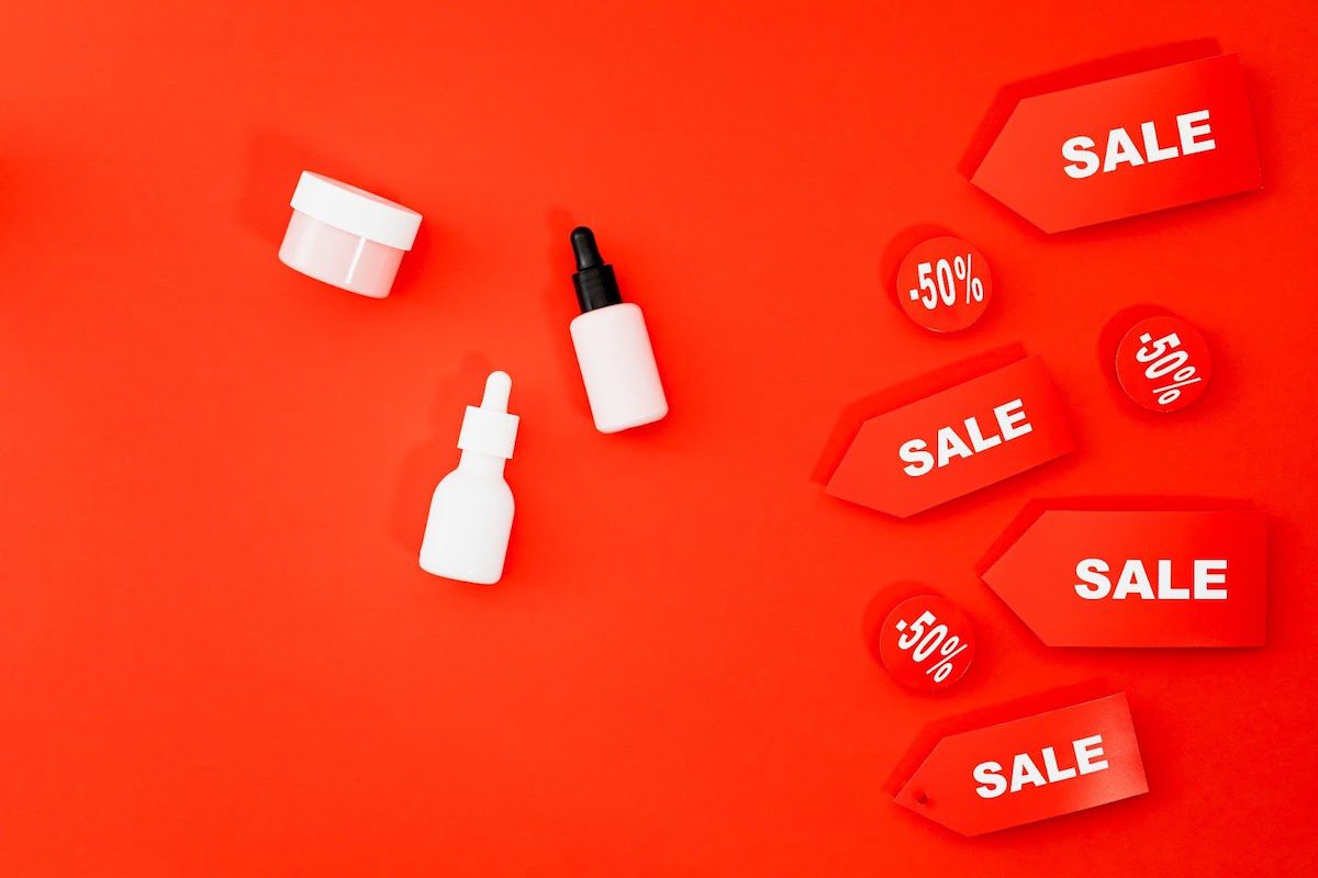 Red background with three unlabeled products and signs indicating a 50 percent sale.
